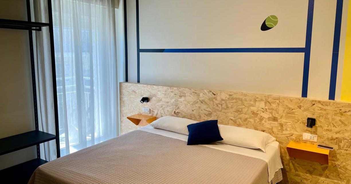 Camera moderna con letto matrimoniale, decorazioni minimal e luce naturale.